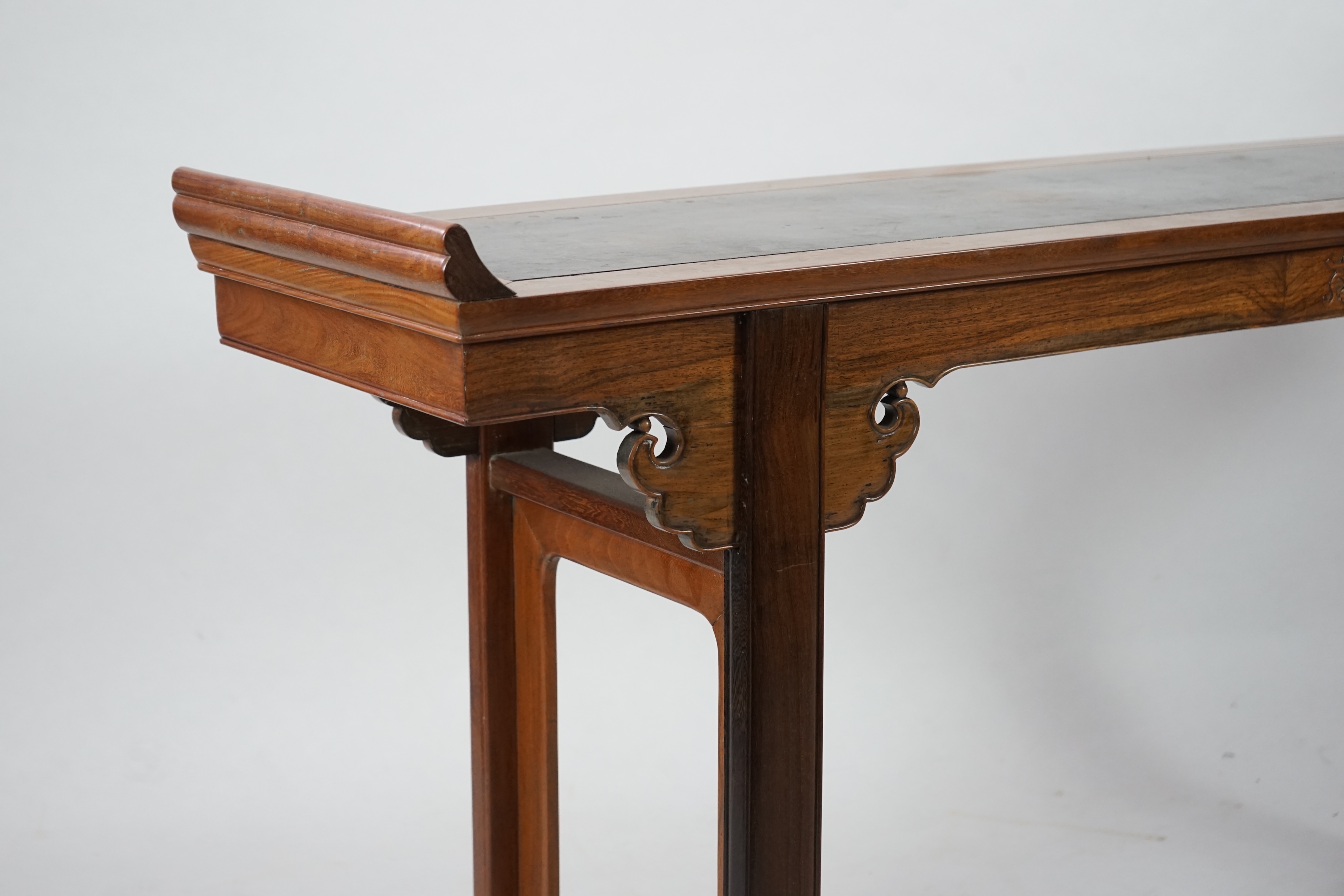 A Chinese padouk wood and jichimu altar table, the panelled rectangular top with scroll ends, on plain uprights headed by ruyi, 185cm wide, 94cm high. Condition - fair to good